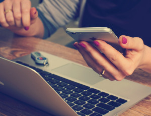 Zdjęcie przedstawiające rękę trzymającą telefon komórkowy